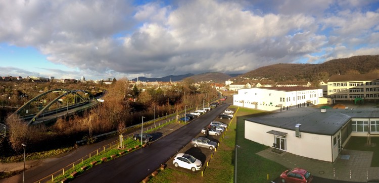 Foto: Blick aus einem EDV-Raum nach Norden. Man sieht Teile des Parkplatzes, Turnhalle, Cafeteria, Pausenhof und den B-Flügel - und natürlich den Odenwald und seine Ausläufer.